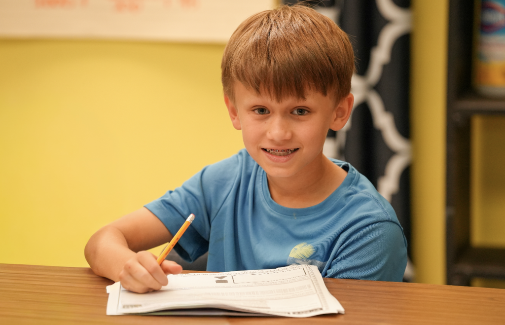 Student smiling while working at desk
