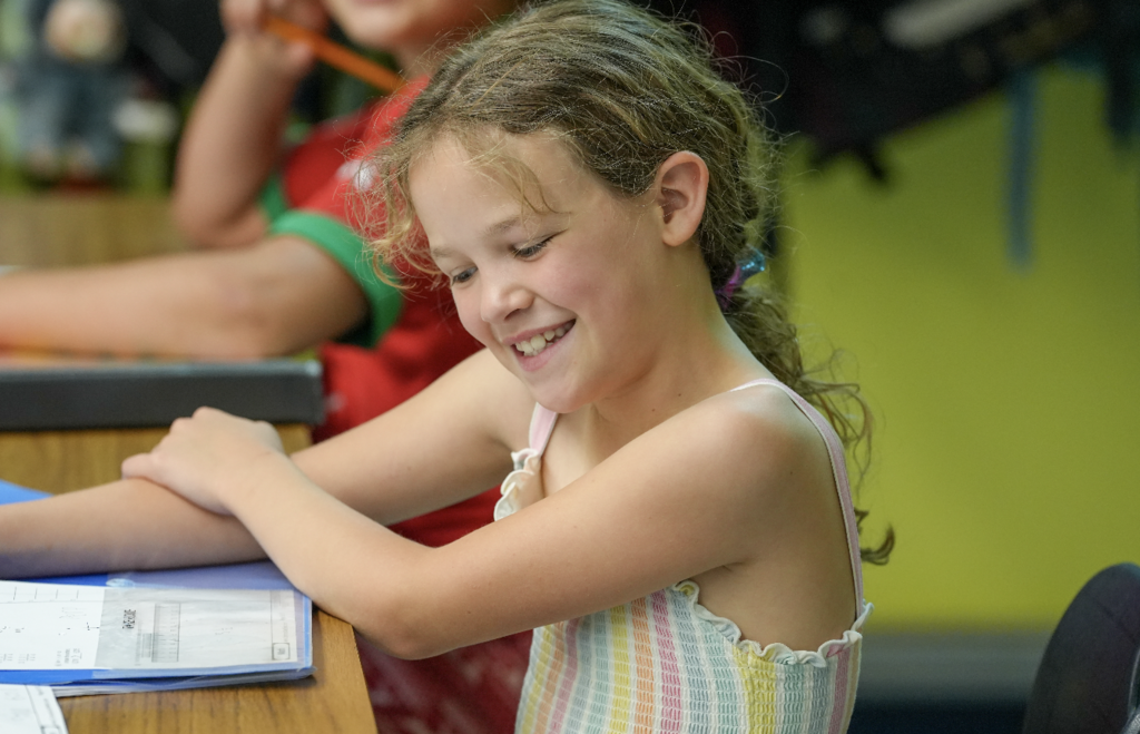 Student smiling while working at desk