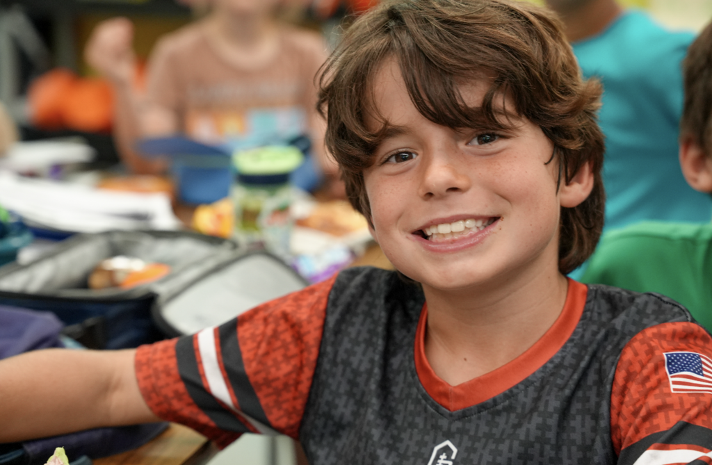 Student smiling while working at desk