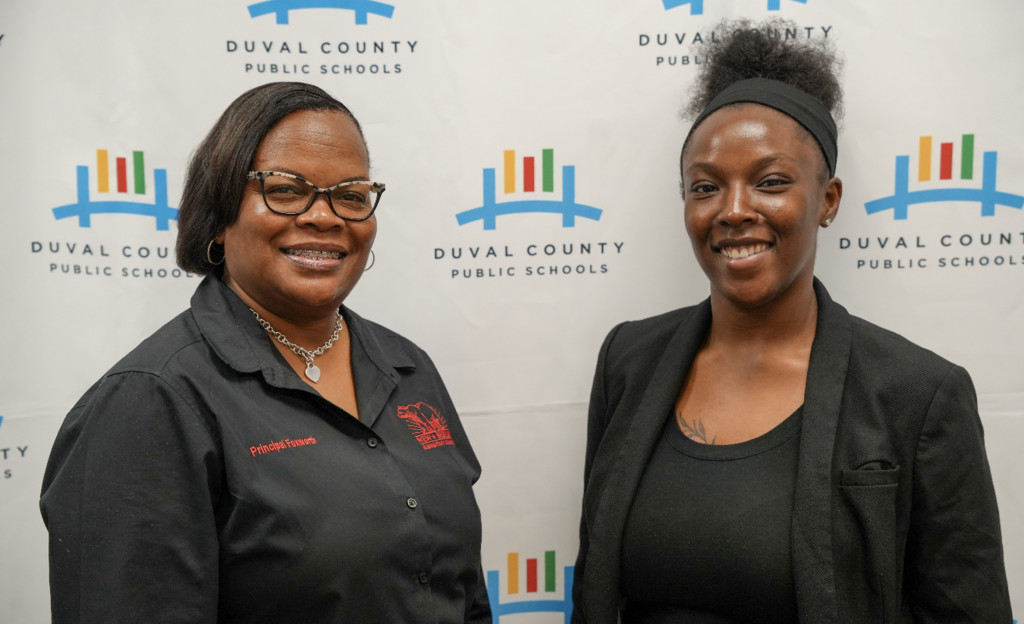 Two attendees smiling and standing together at the hiring fair