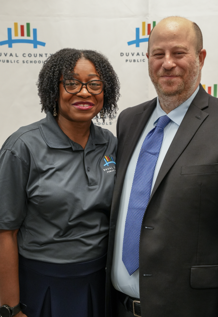 Two attendees smiling and standing together at the hiring fair