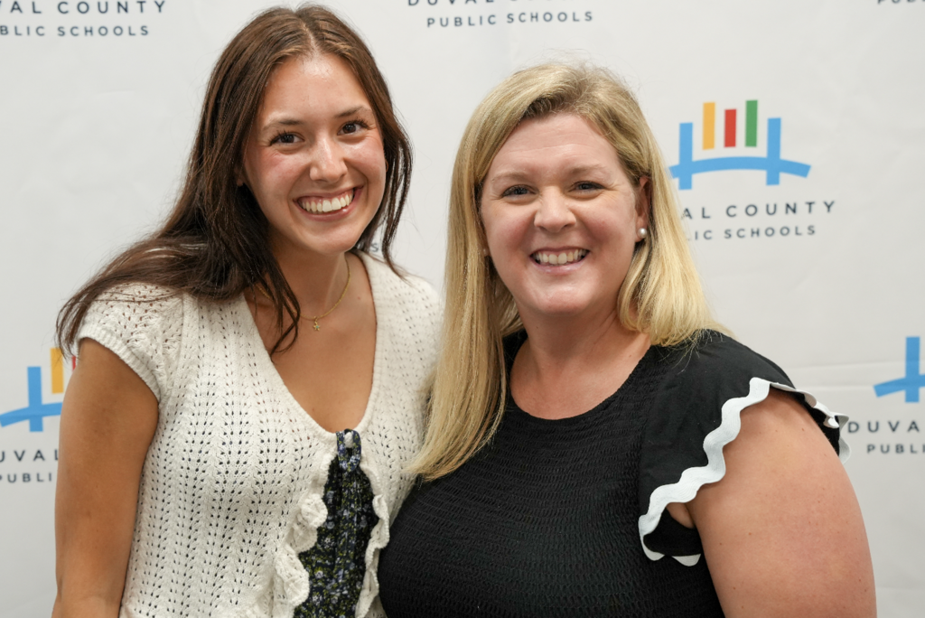 Two attendees smiling and standing together at the hiring fair