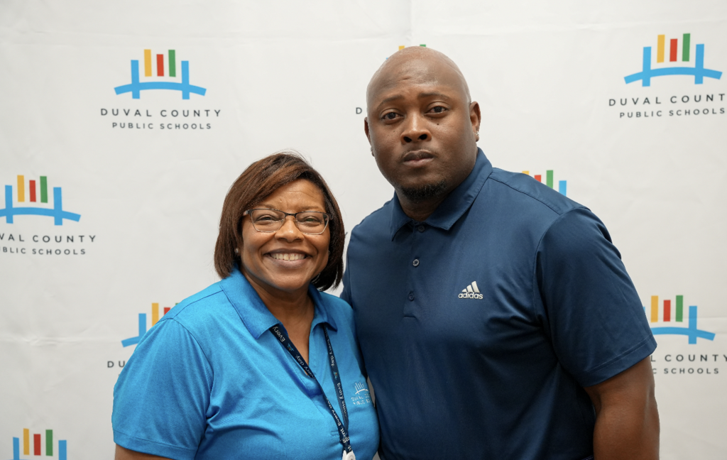 Two attendees smiling and standing together at the hiring fair