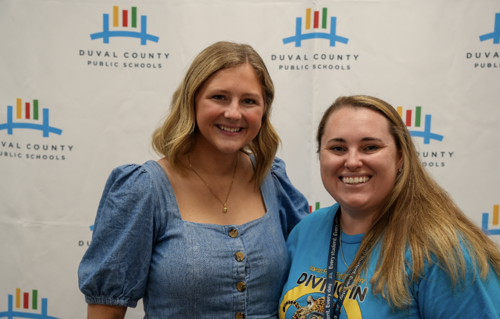 Two attendees smiling and standing together at the hiring fair