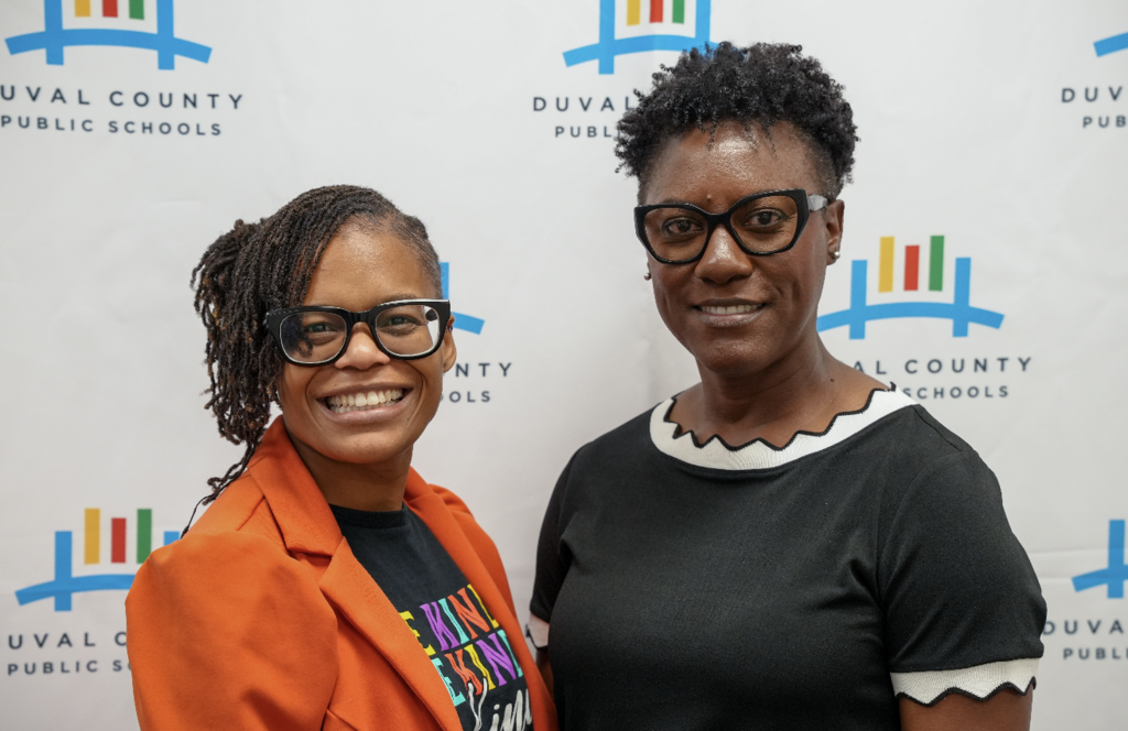 Two attendees smiling and standing together at the hiring fair