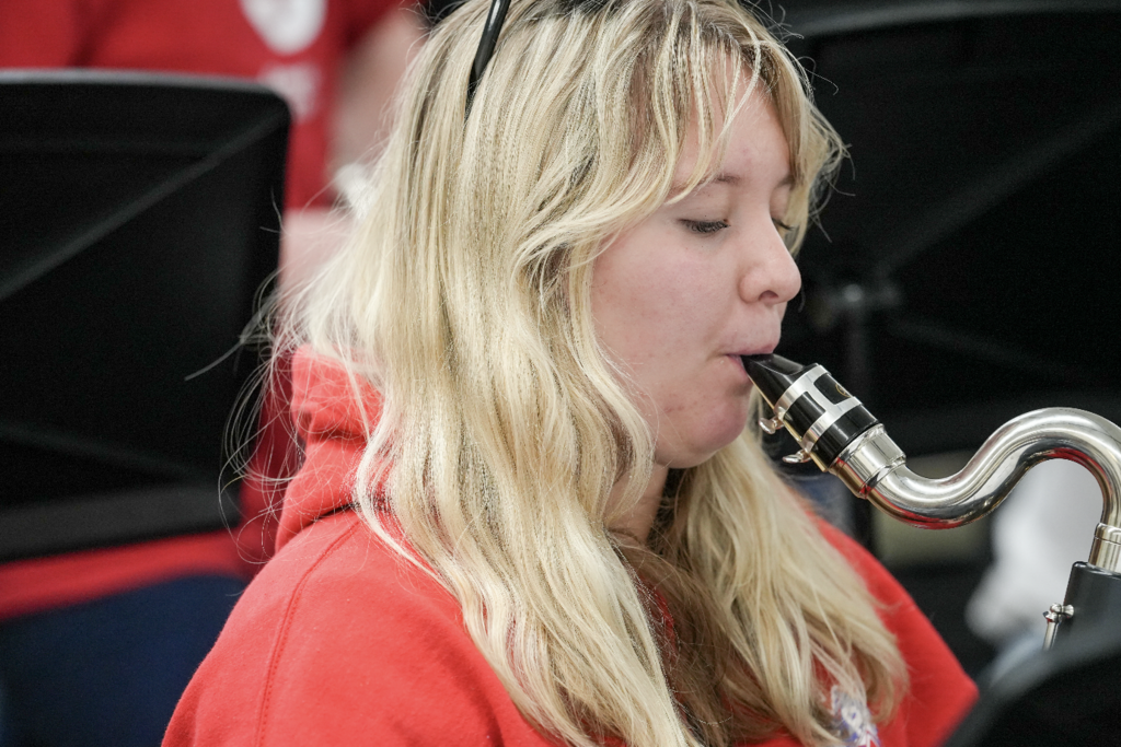 Student playing a woodwind instrument, focused during rehearsal
