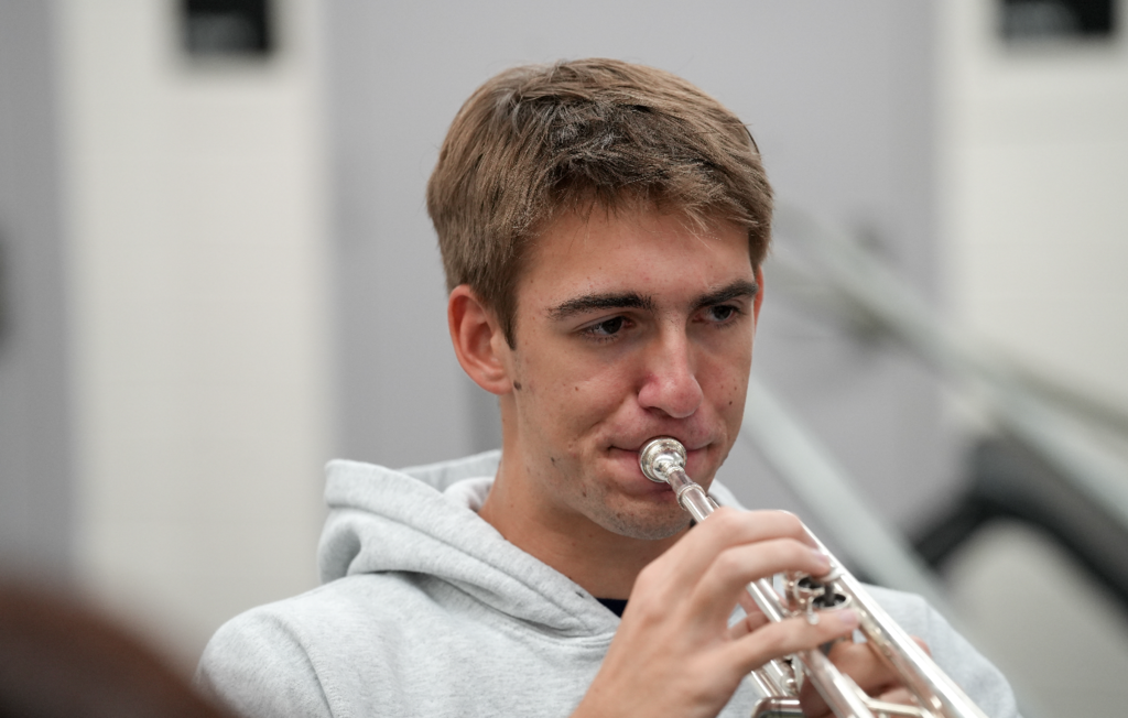 Student playing a trumpet in a band class