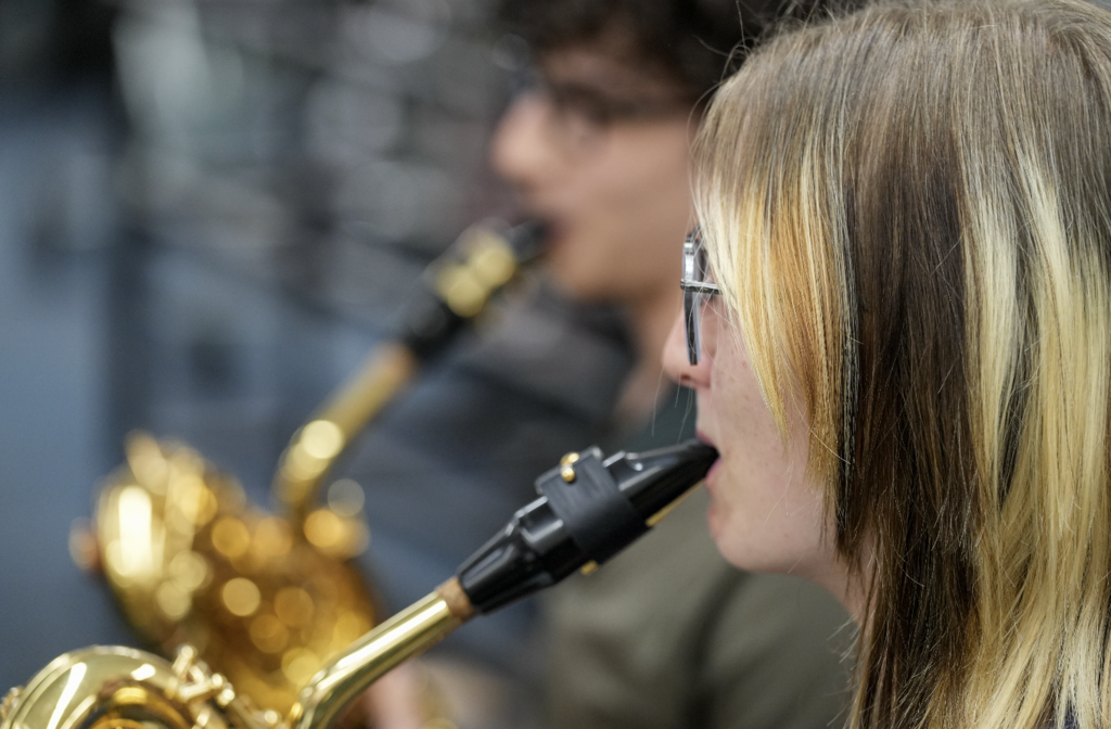 Close-up of a student playing a saxophone during band practice