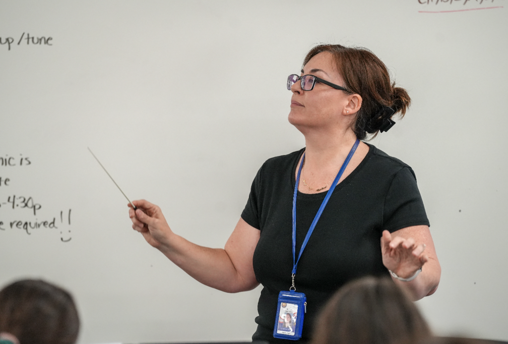 Cristina Ledford conducting with expressive hand movements during rehearsal