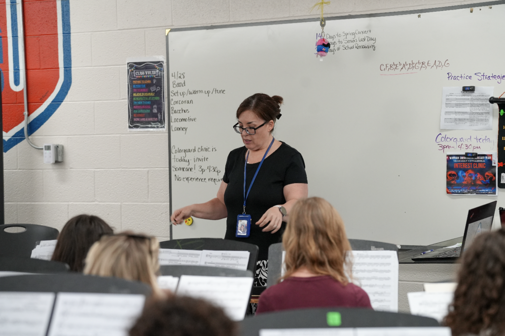 Cristina Ledford conducting while students play instruments in a classroom setting