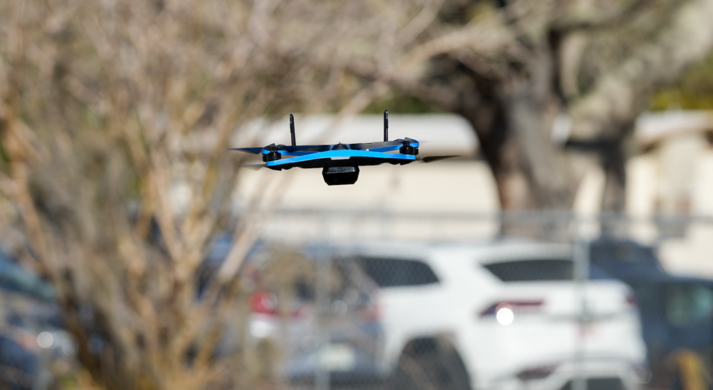 Drone flying low over a grassy area near the school