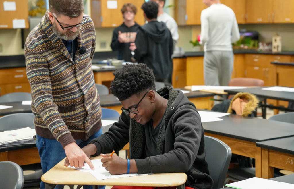 Student works with classmates during a hands-on classroom activity.