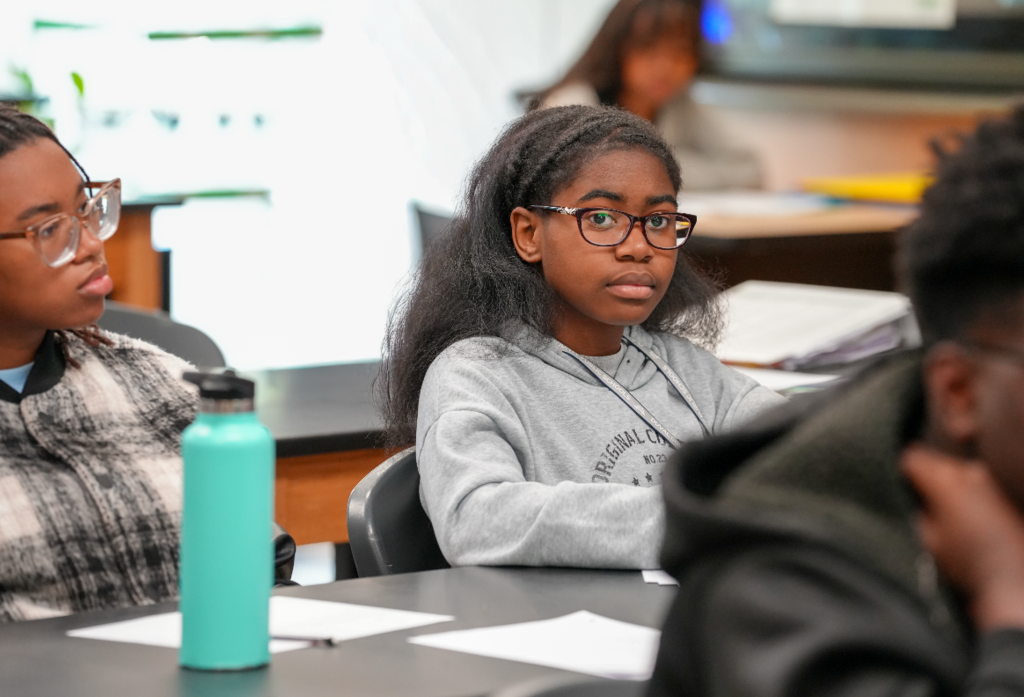 Student looks forward and listens during an active classroom lesson.
