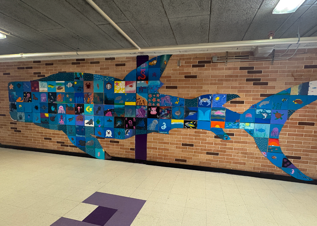 A mural of a whale shark made up of student illustrations of various sea creatures.