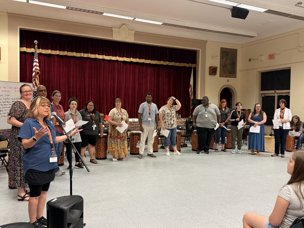 A group of music teachers gathers in the auditorium at Fishweir Elementary School.