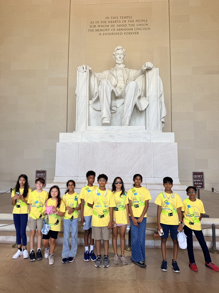 A group of safety patrol students stands smiling in front of the Lincoln Memorial in Washington, D.C.