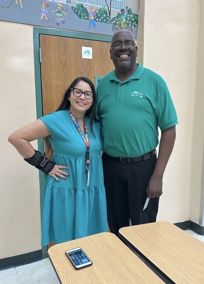 Principal Simpson of Central Riverside Elementary stands smiling next to Ingrid Carias, ESOL program director.