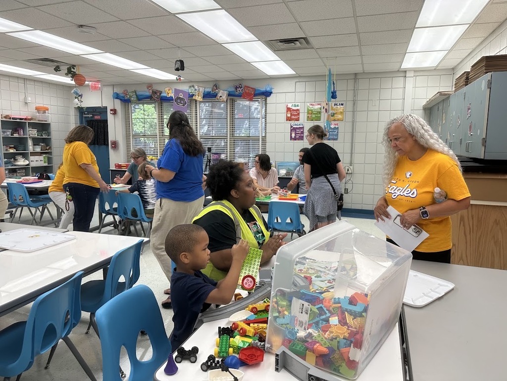 Principal talking to a parent and child while they explore LEGOS