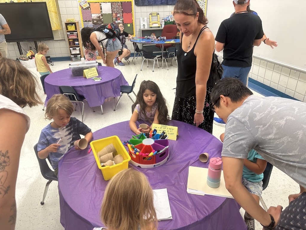 A group of students and parents around a table doing an activity together