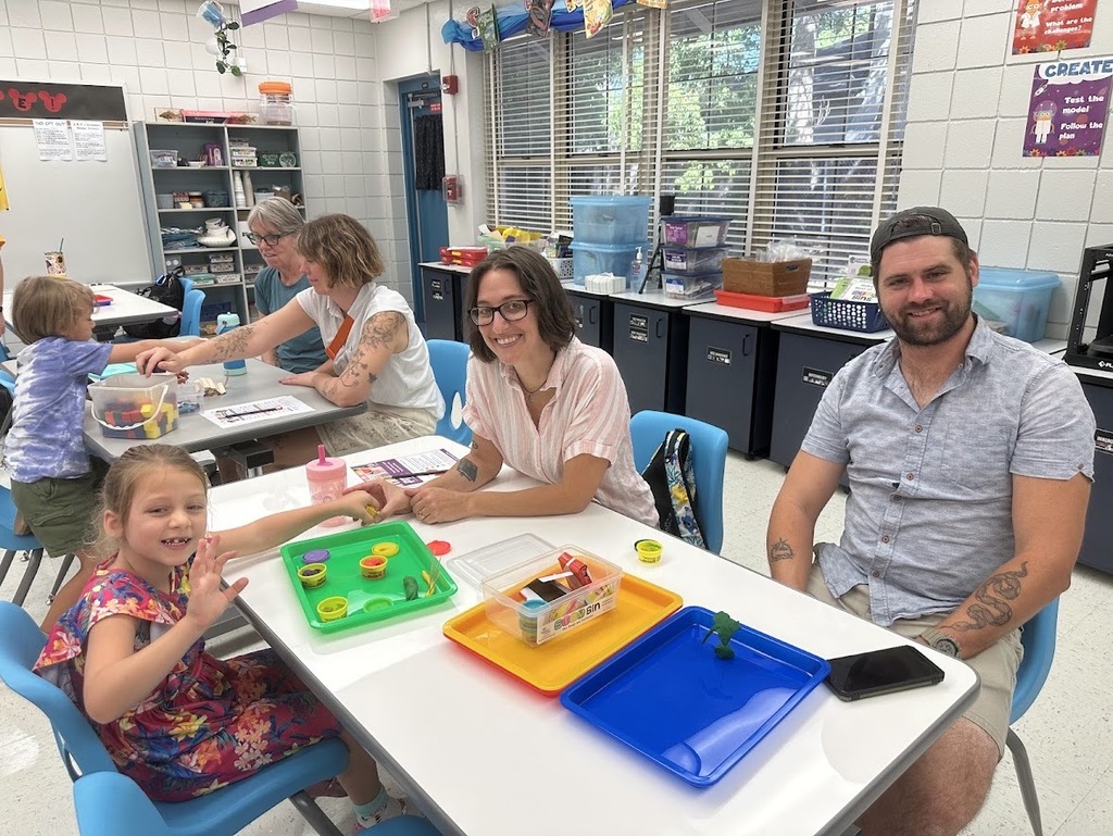 A mom, dad, and daughter at a table together using Playdoe