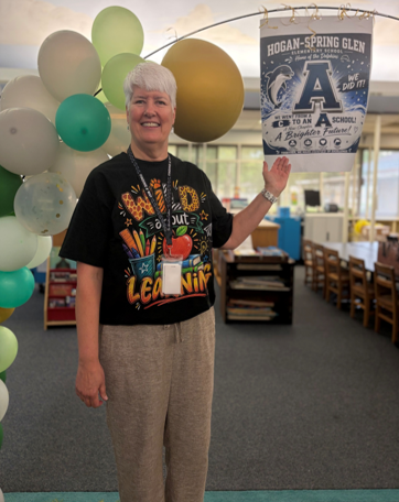 Principal Stalls stands in front of a poster celebrating Hogan Spring Glen Elementary's A rating for the 2025 - 2026 school year.