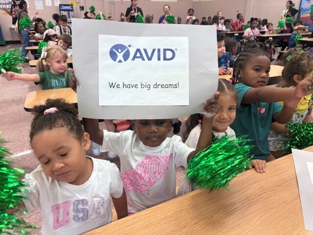 A group of Arlington Heights Elementary students wave pom-poms at a pep rally for the AVID program.