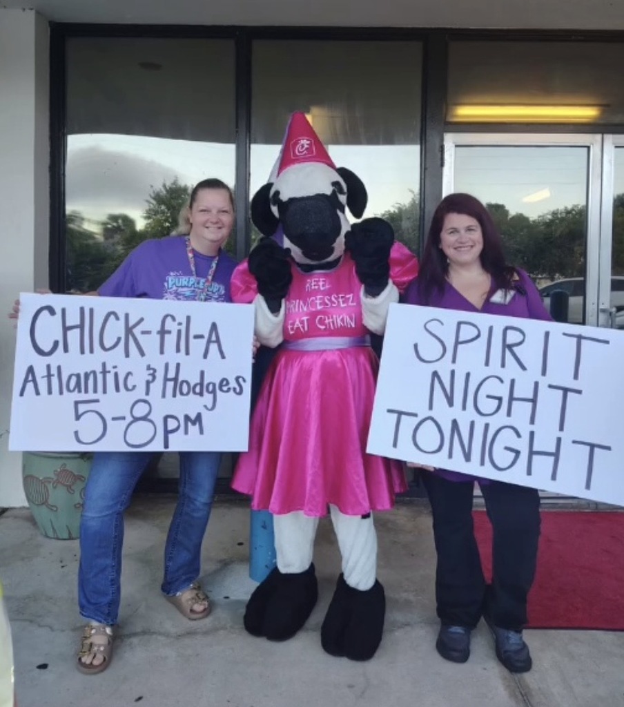 Two people standing with the Chick-Fil-A mascot holding signs with information about spirit night.