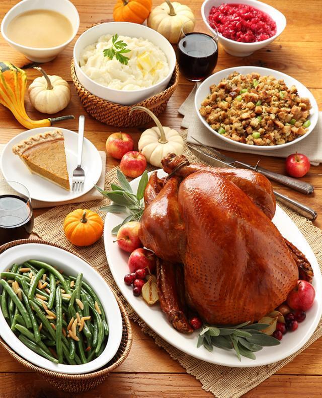 Thanksgiving feast with turkey, mashed potatoes, cranberry sauce, gravy. pumpkin pie, green beans, and dressing