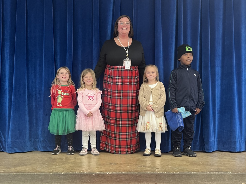 Principal Coffman stands smiling with four of her Seabreeze Elementary students. 