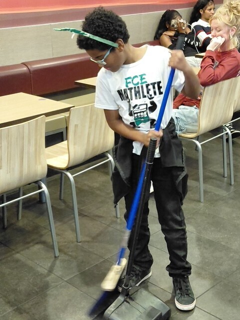 Guys with Ties student sweeps the floor at last year's McDonald's School Spirit night