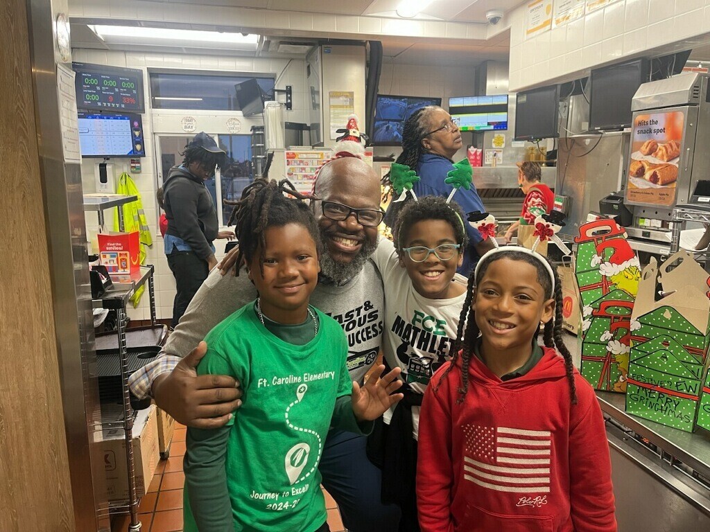 Mr. Goodman, the sponsor for Guys with Ties and a three students working at McDonald's School Spirit Night Last Year