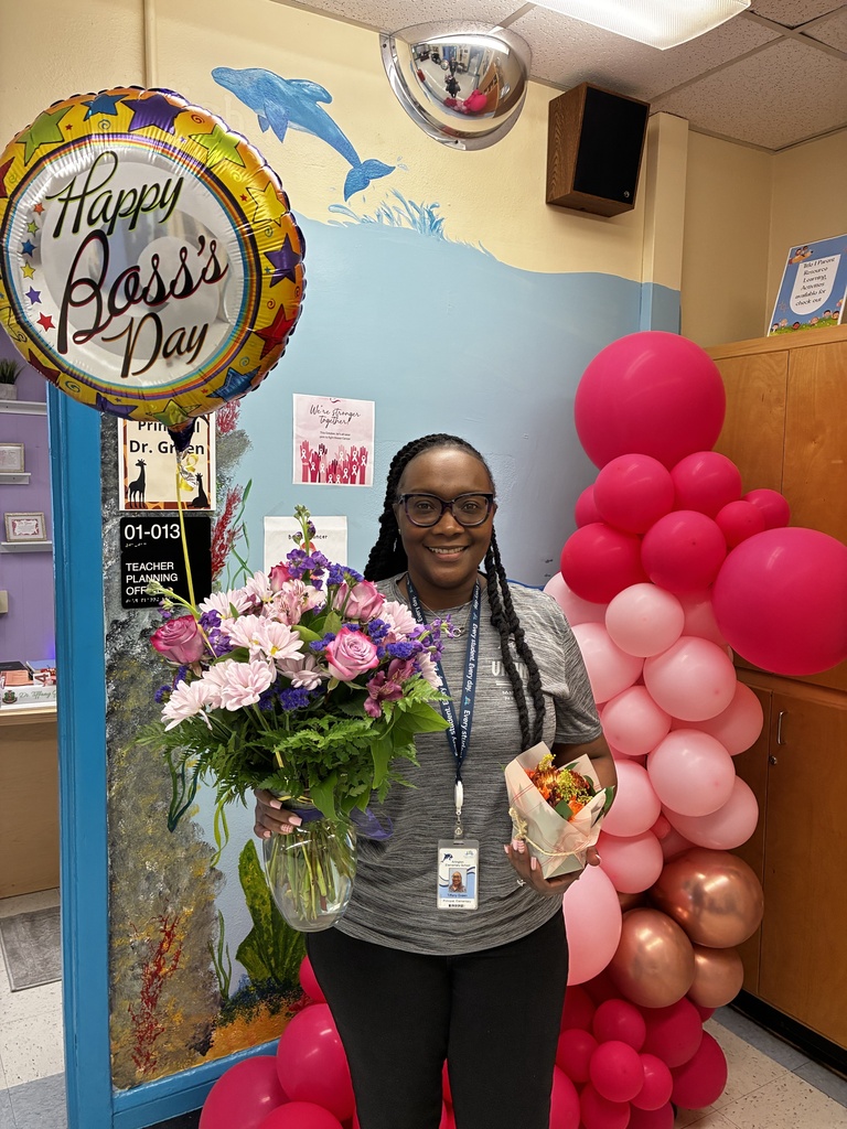 Adult holds flowers in front of pink balloons