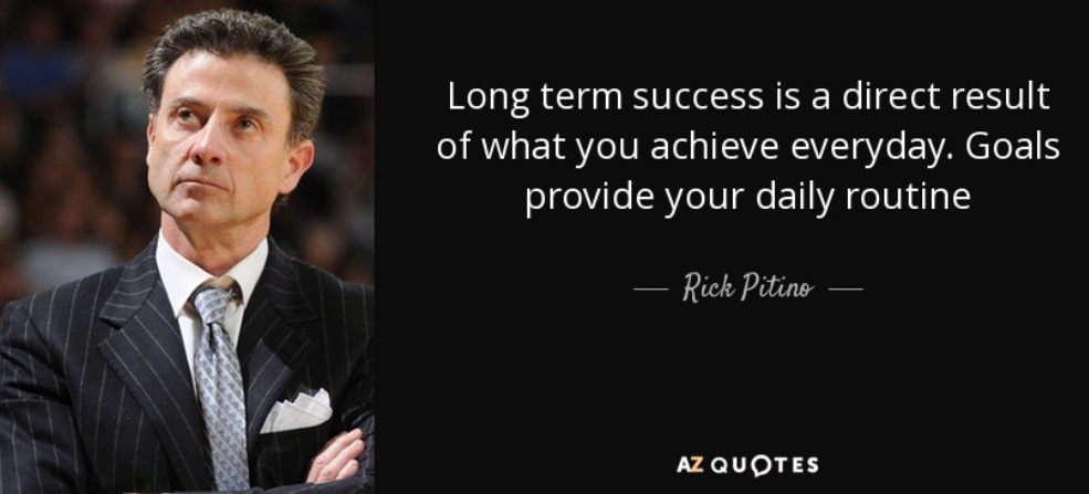 A man in a suit with crossed arms, looking to the right, has a motivational quote.