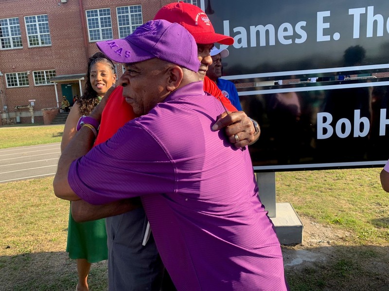 Two gentleman embrace following the dedication ceremony