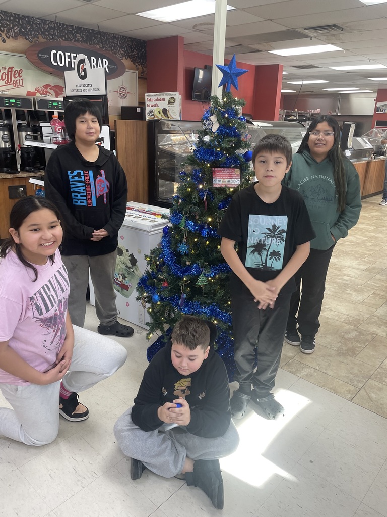 Helpers in front of their decorated tree at Eagle Butte Co-Op.