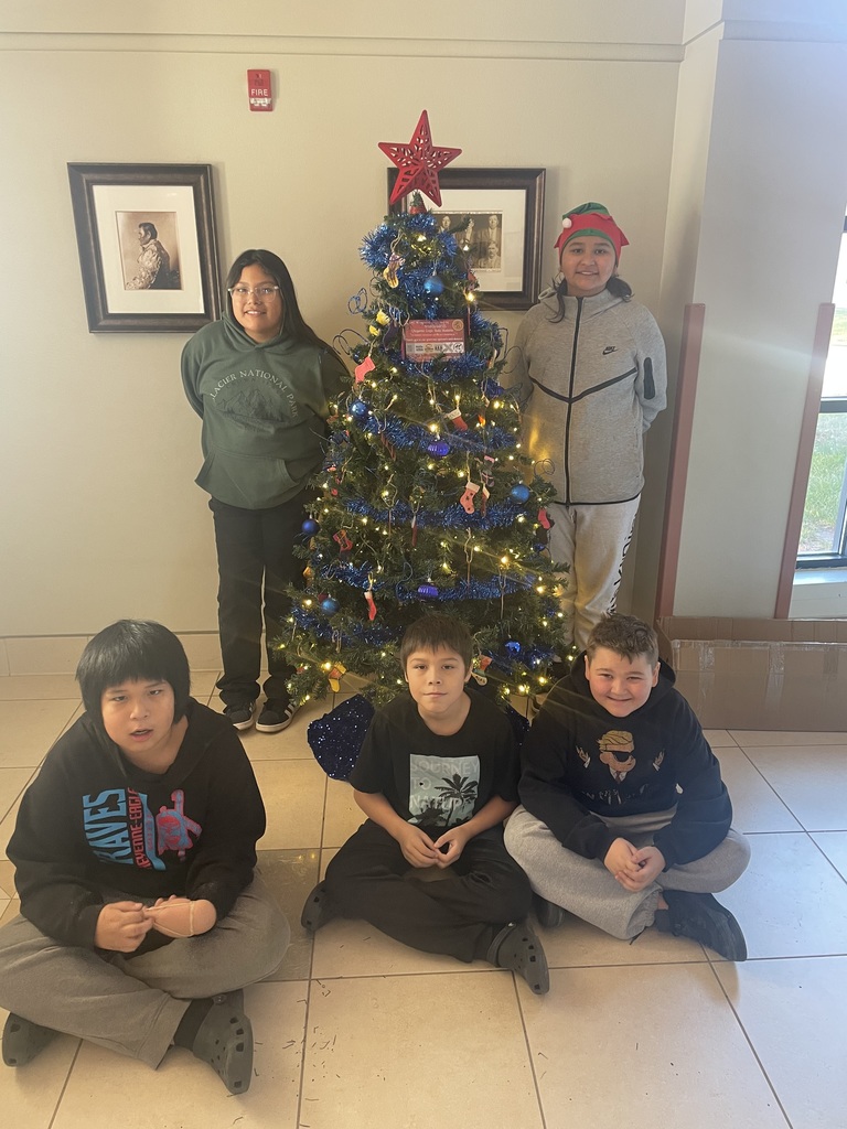 Helpers in front of their decorated tree at IHS.