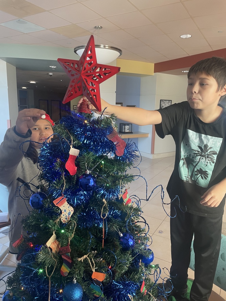 Helpers decorating tree at IHS.