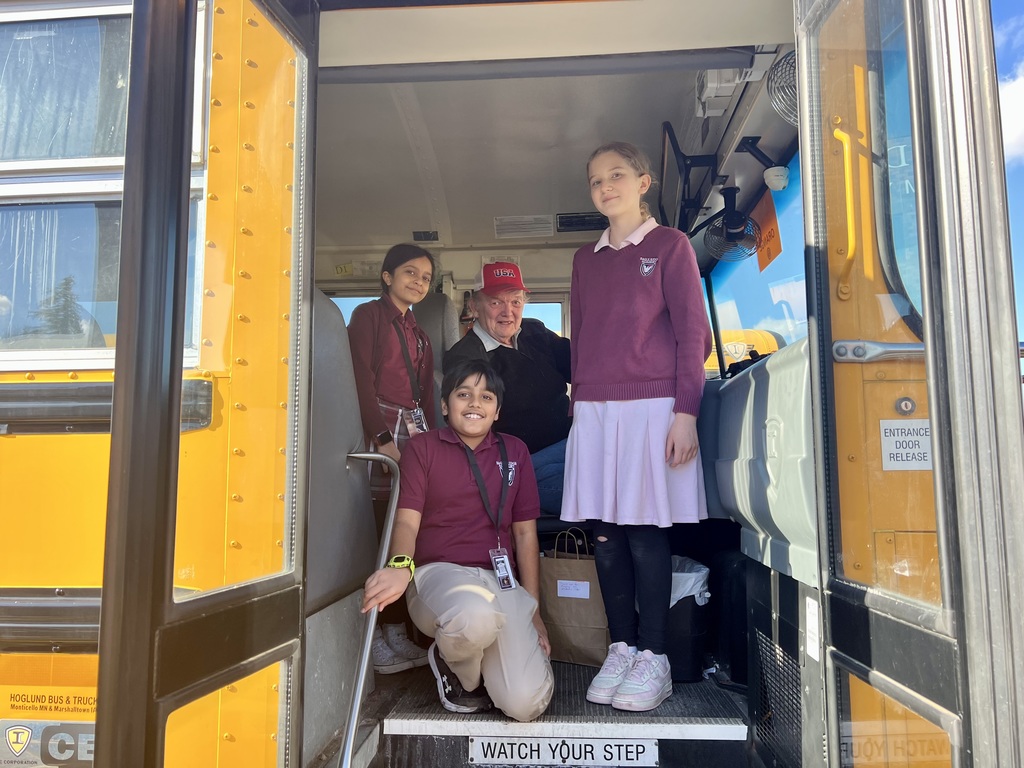 three students with a bus driver