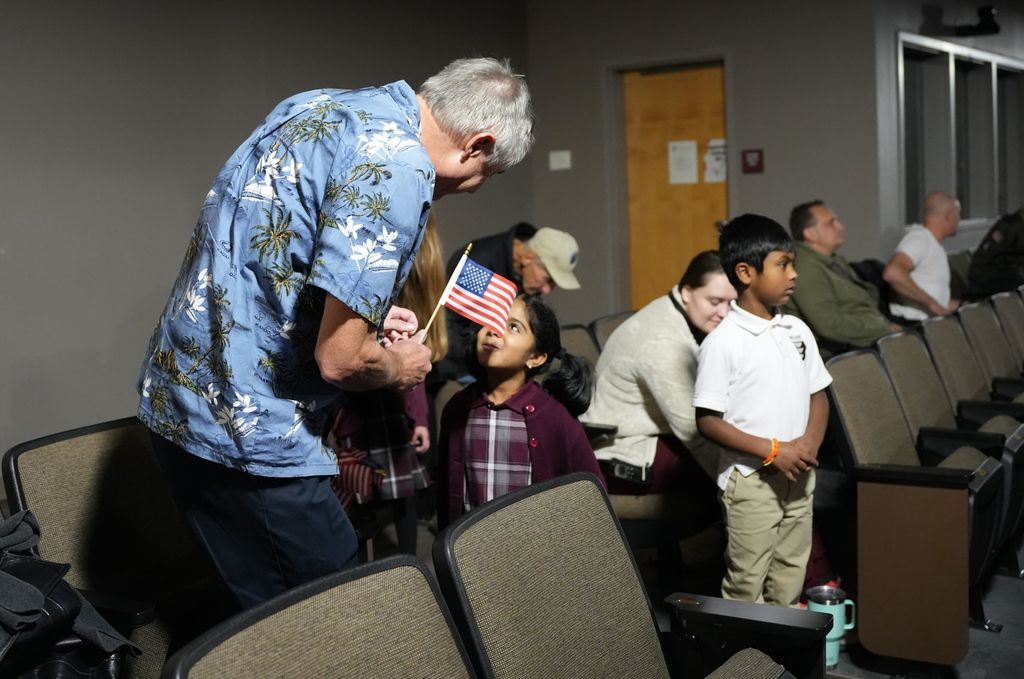 kindergartener giving flag to vet