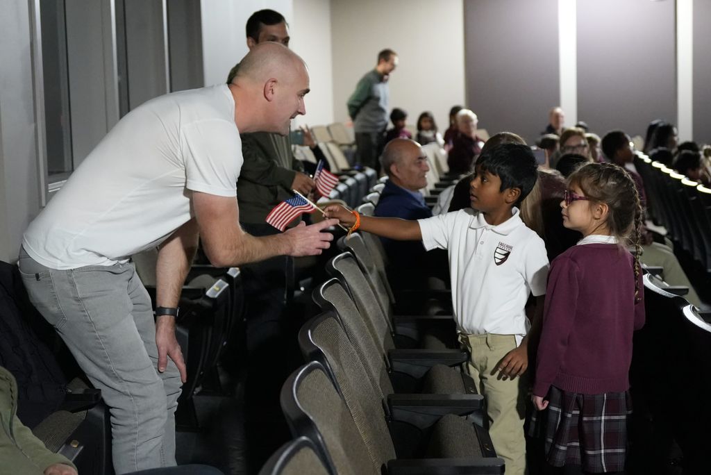 kindergartener giving flag to vet