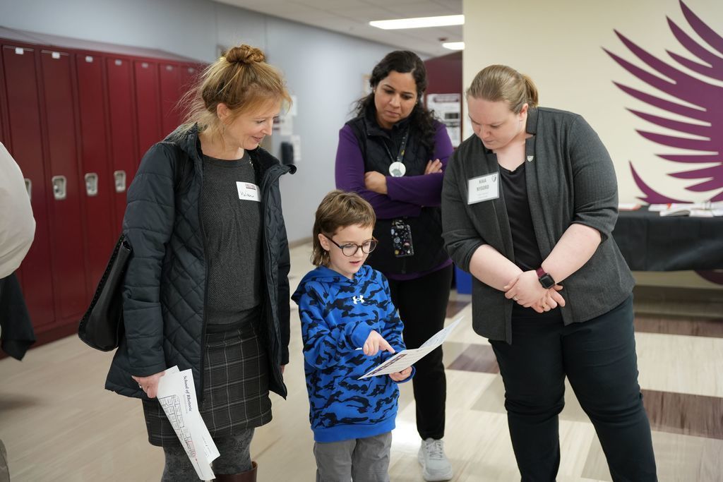 child with parent and staff member
