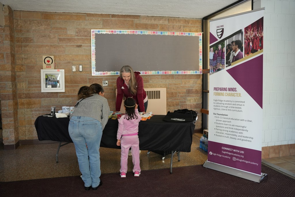 two children and a mom picking out snacks from the welcome table.