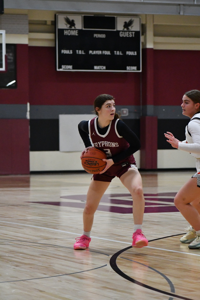 a girls varsity basketball player getting ready to throw the ball
