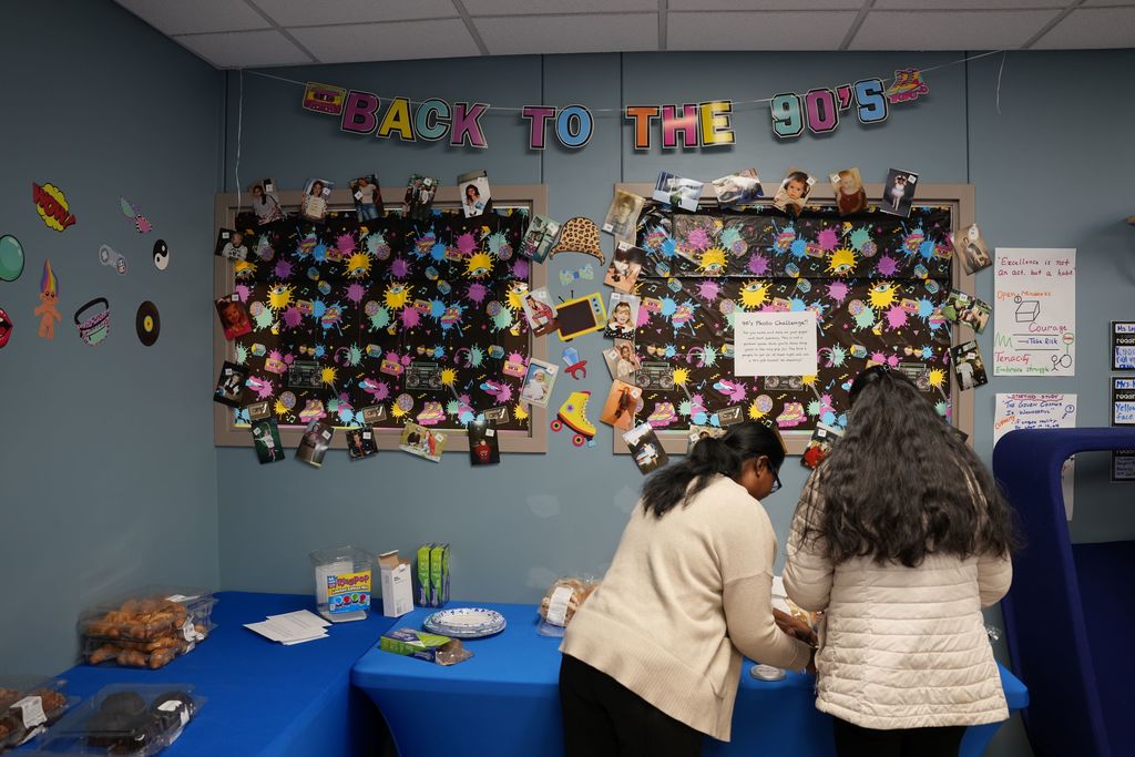 staff in front of 90s decorations