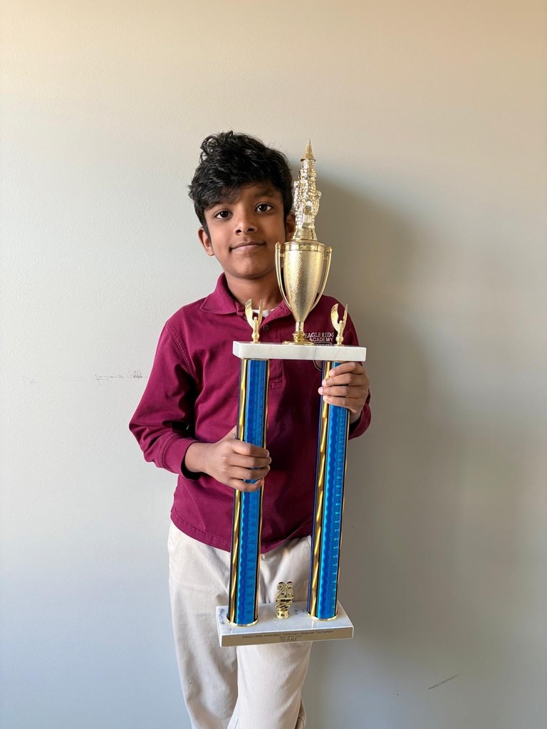 student holding chess trophy