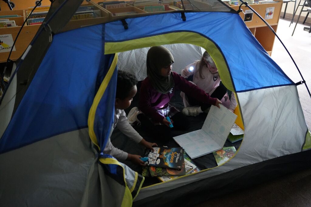 students reading in tent