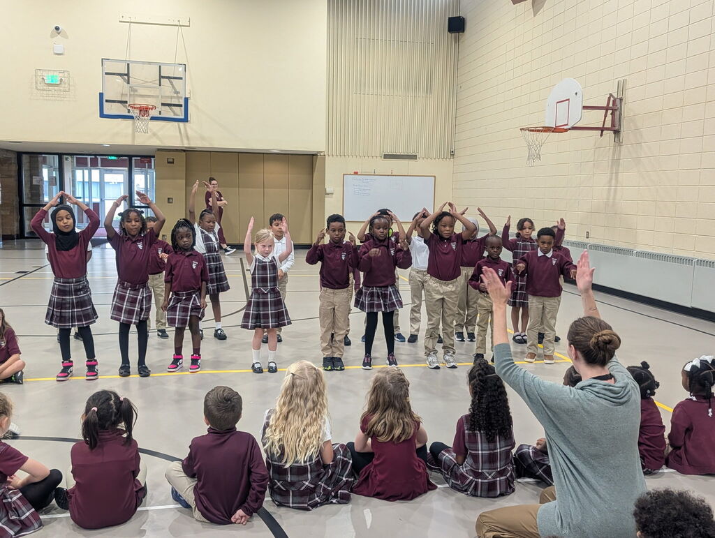 students in a line with hands above their heads