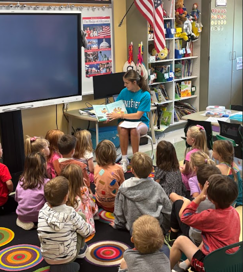 unified team member reading parkdale students a book