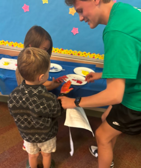 unified member helping parkdale students make handprints
