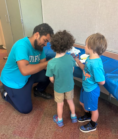unified member helping parkdale students make handprints